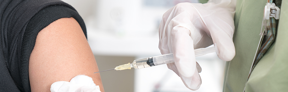 A doctor preparing to inject a vaccination.