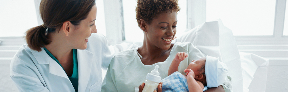 Doctor interacts with mother and newborn